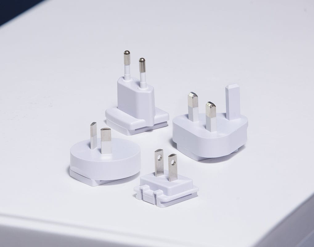 The four interchangeable plug adapters: EU, UK, AU and US
