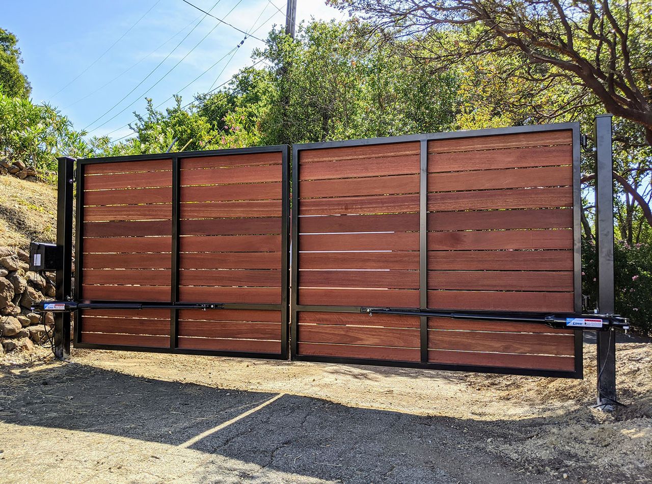 Wide black steel double driveway gate with horizontal wood privacy infill